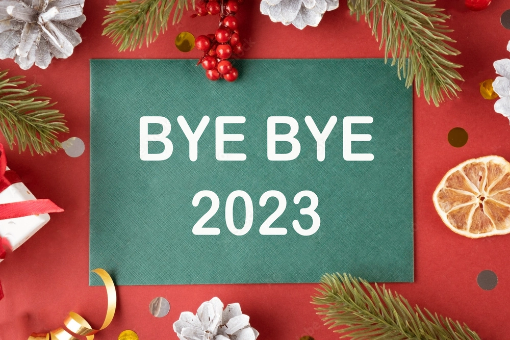 Bye bye 2023 text on green new year card on red background with new year attributes