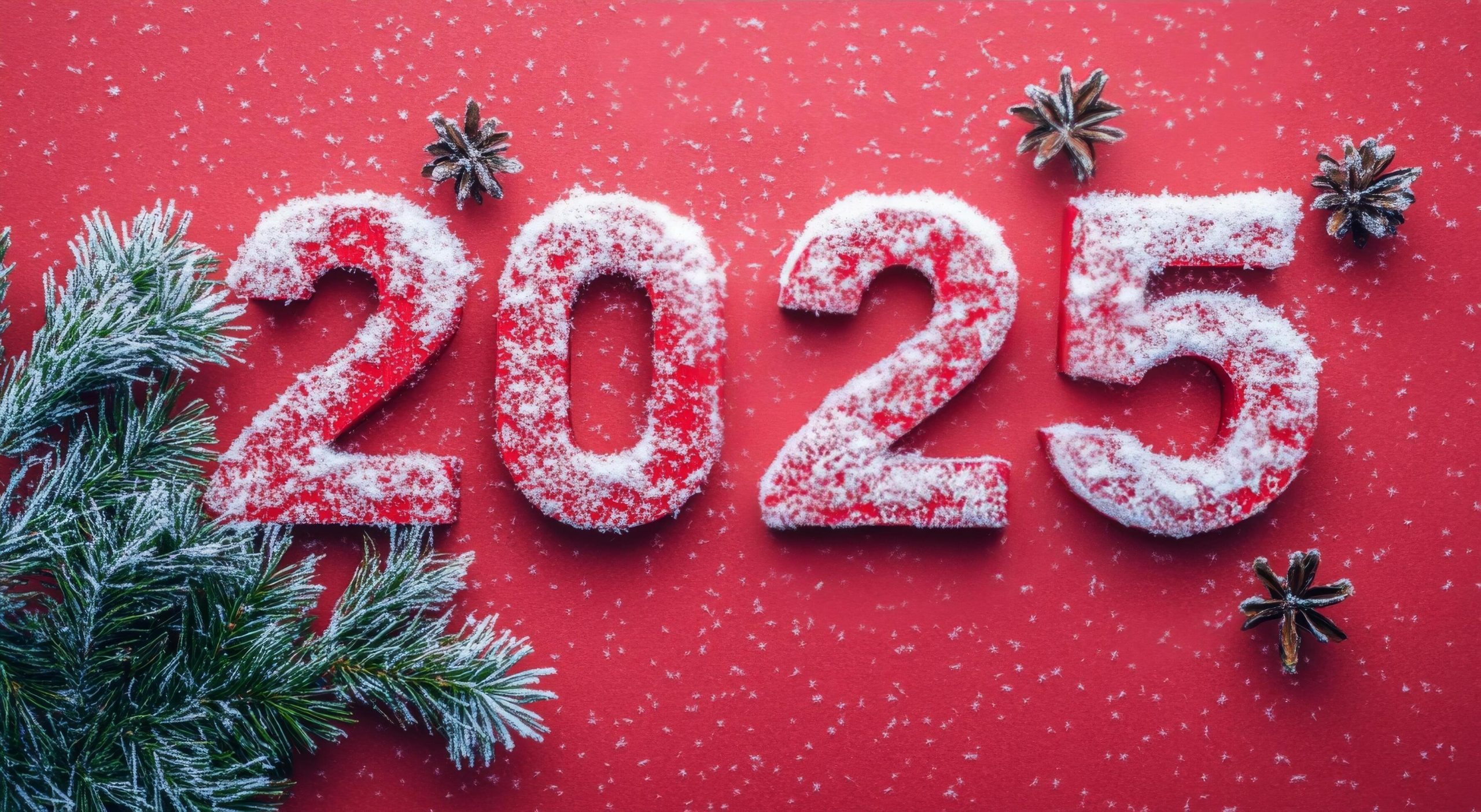 Festive snow covered numbers 2025 adorned with greenery on a bright red background free photo